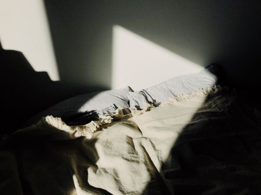 Lumière naturelle sur du linge de lit, évocation du sommeil et de la récupération